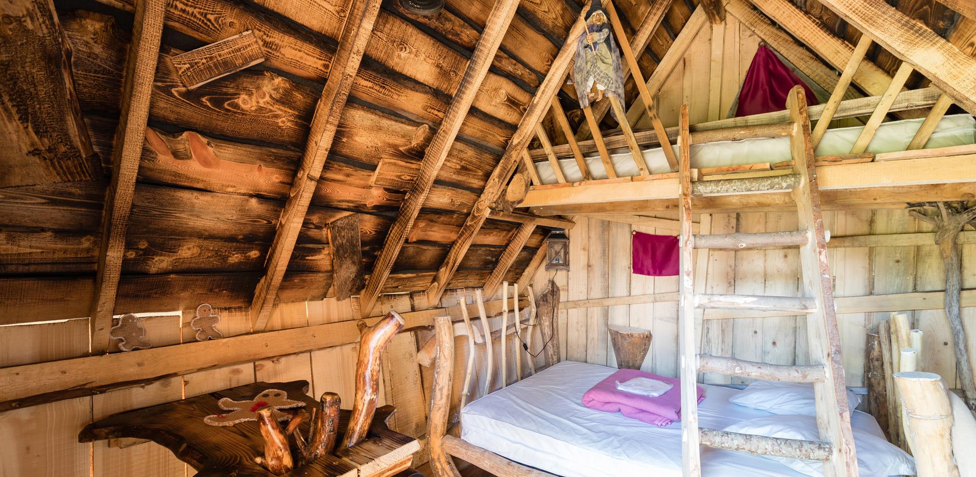 Location d'hébergements insolites dans les Vosges : vue d'un coin chambre d'une cabane insolite