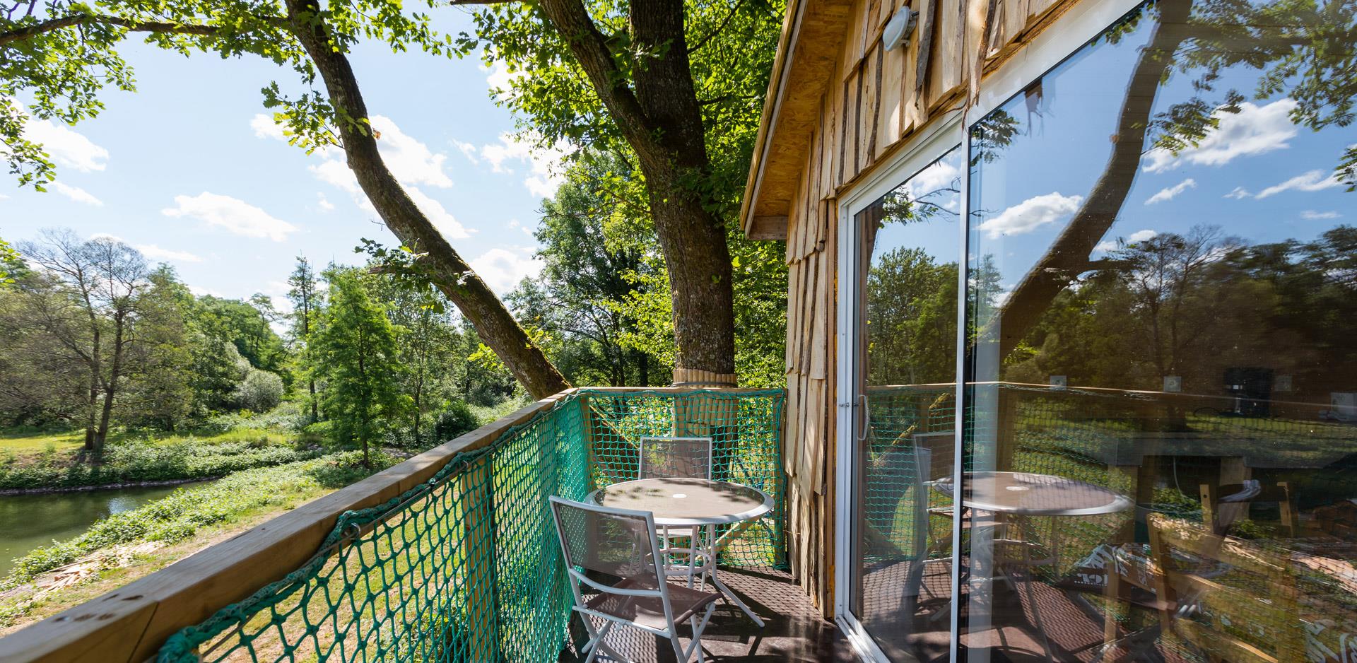 Le salon de jardin de la terrasse de la cabane suspendue Robin des Bois, hébergement insolite dans le Haut-Rhin au camping les Castors