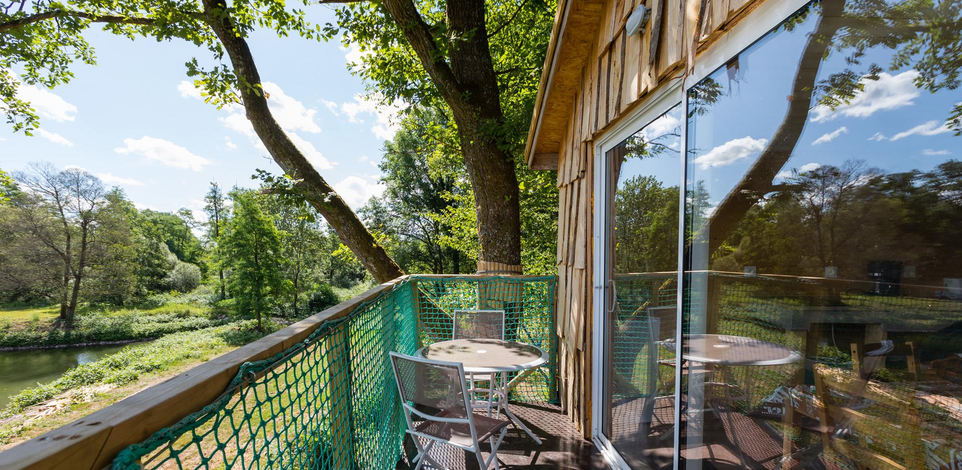 Outside furniture on the terrace of the suspended in the trees hut Robin Hood, atypical accommodation in the Haut-Rhin at the campsite Les Castors