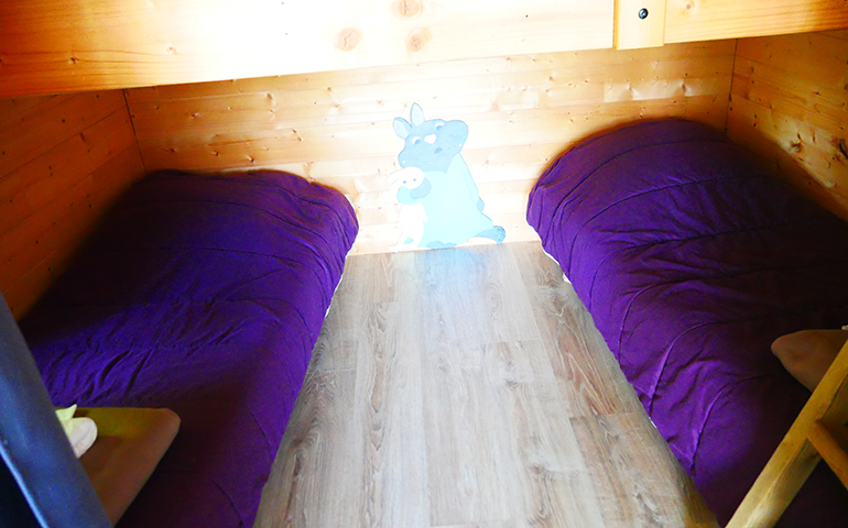 Bedroom with a double bed in the suspended in the trees hut Robin Hood, rental of atypical accommodations at the Campsite Les Castors near the Vosges Mountains