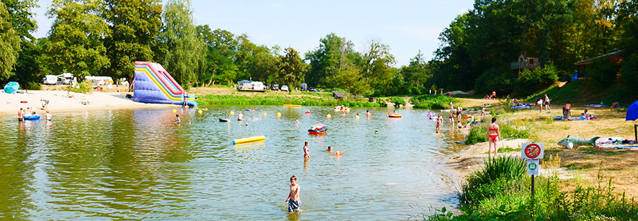 Naturbad mit Rutsche und aufblasbaren Elementen auf dem Campingplatz Les Castors, Ferienvermietung im Elsass